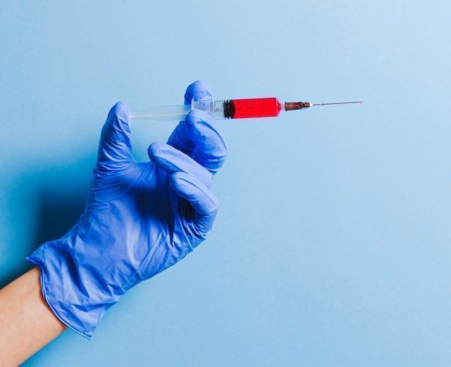 nurse holding syringe 3786234