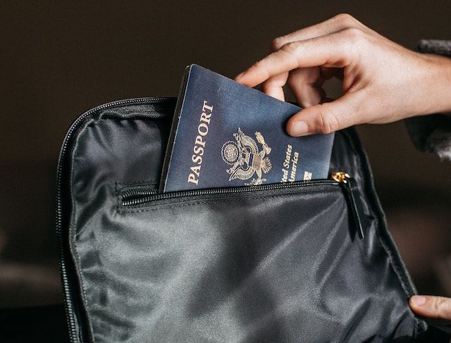 person putting a passport on bag 842961