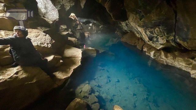 Eva junto a la poza de agua azul de la cueva Grjótagjá