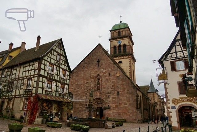 Foto típica de Kaysersberg, la iglesia de la Santa Cruz y delante de ella la Fuente Constantin
