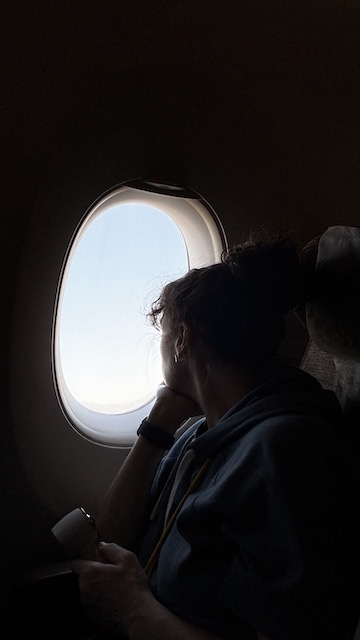 Eva mirando por la ventanilla de un avión durante un viaje a Japón