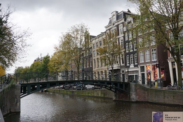 Canal con puente y casas tradicionales en el centro de Ámsterdam